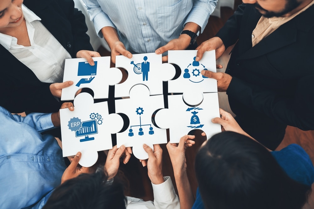 A,Diverse,Group,Of,Professionals,Collaborate,Over,Puzzle,Pieces,Featuring